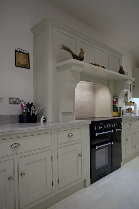 Painted cabinetry framing a range cooker and mantle
